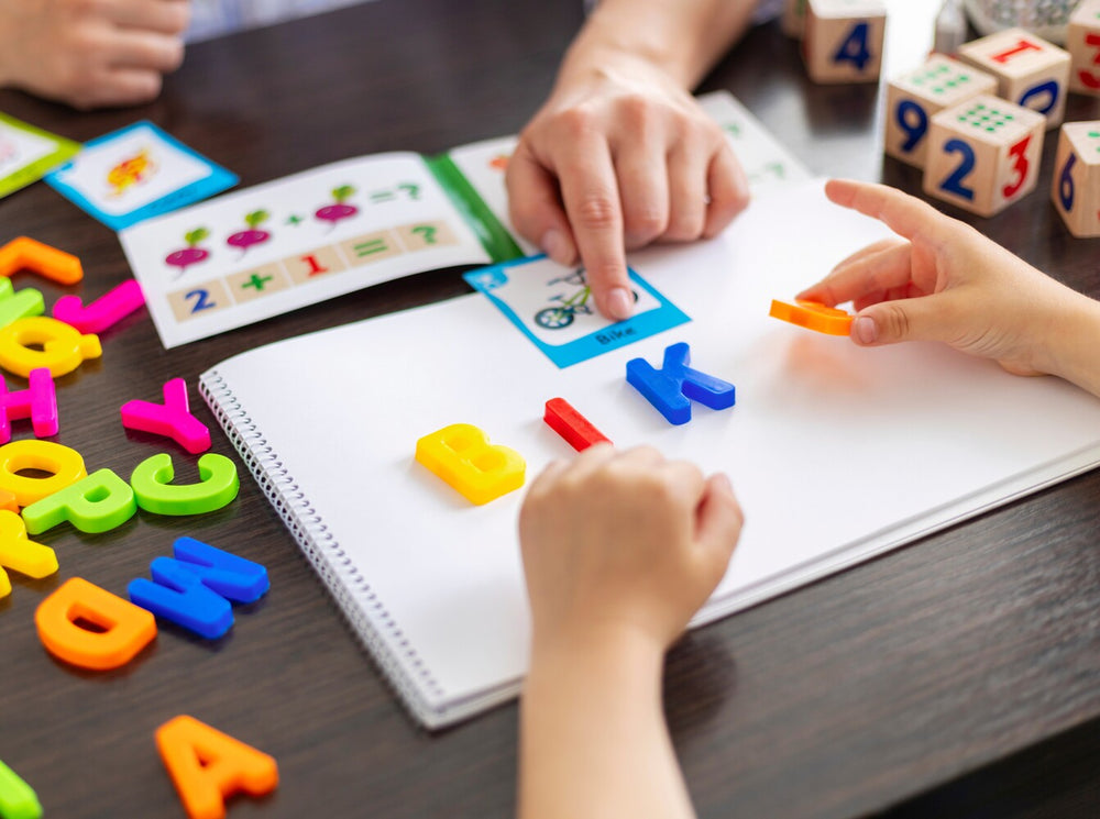 children playing a game using colorful letters to spell words, showcasing what are the best ways to teach kids spelling