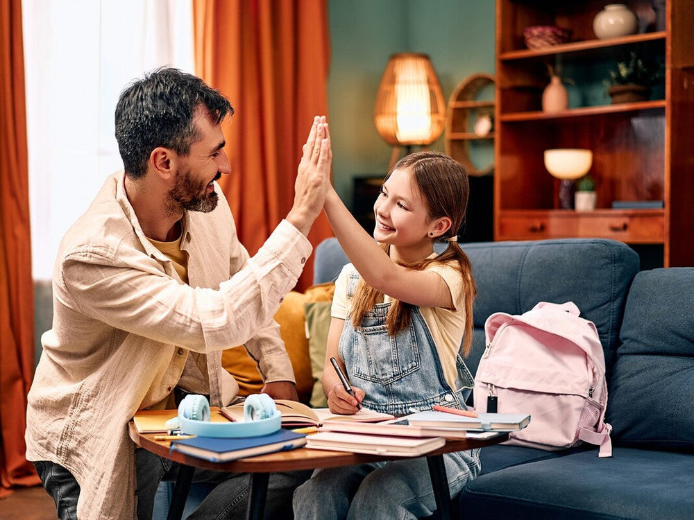dad helping his daughter do the best summer workbooks for kids