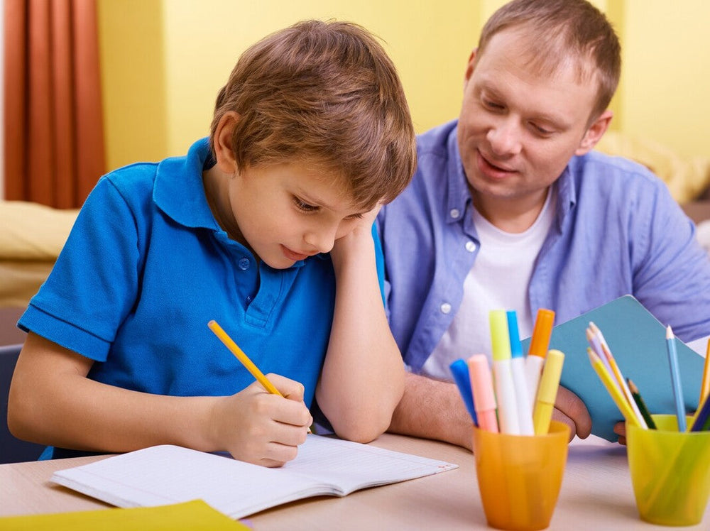 father helping his son work through the best 2nd grade workbooks