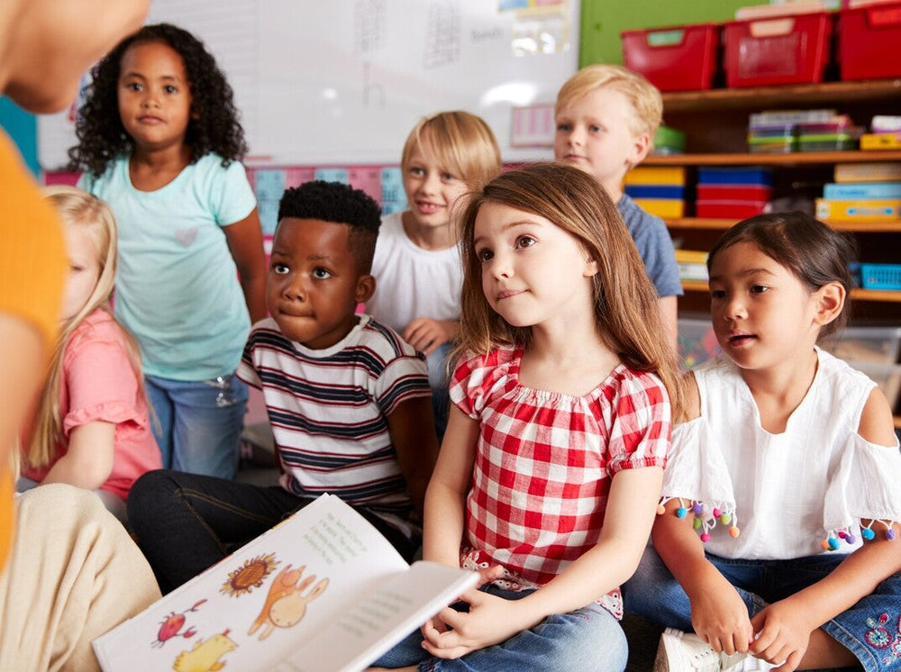 group of children all engaging in active listening for kids while their teacher reads a story
