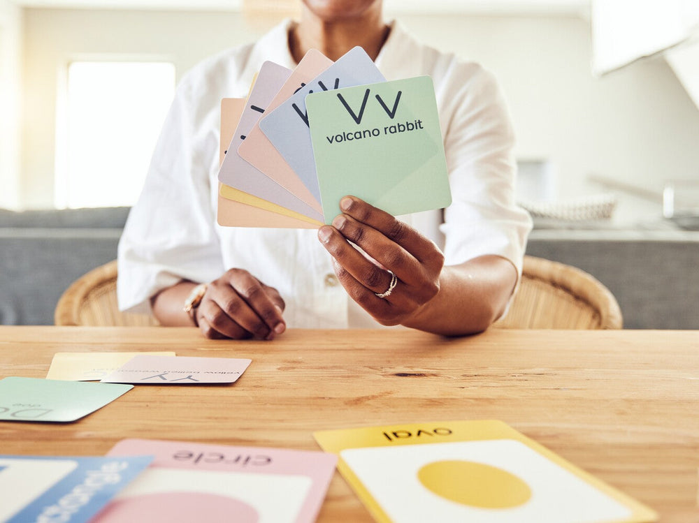 teacher holding up flash cards with words and letters for phonics and how to teach a child to read