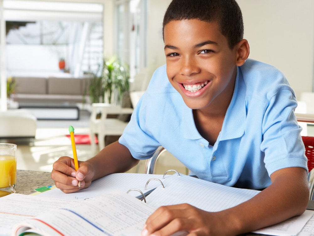young boy smiling because he is having fun while doing the best summer workbooks for 6th grade