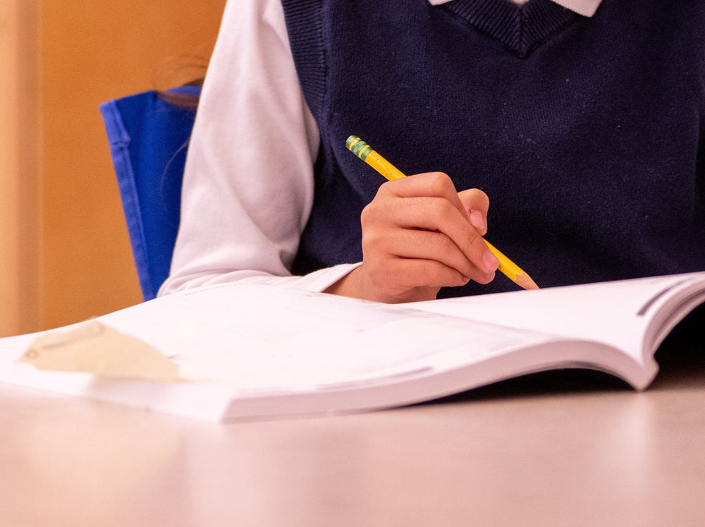 young child using a pencil to do one of the best phonics workbooks at home
