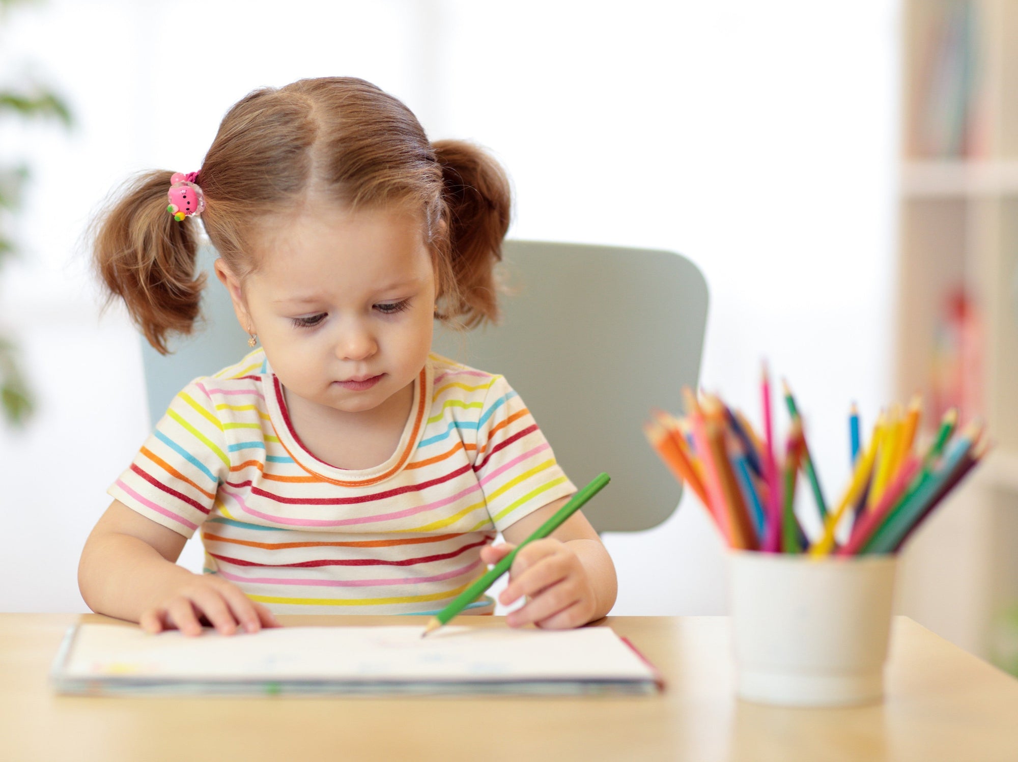 young girl going through the best preschool workbooks at home